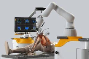 Robotic arm over a mannequin in an orthopedic surgery setup, monitor with x-rays displayed